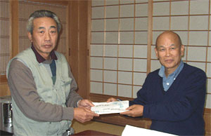 Kodama handed the donation to Mr. Isa